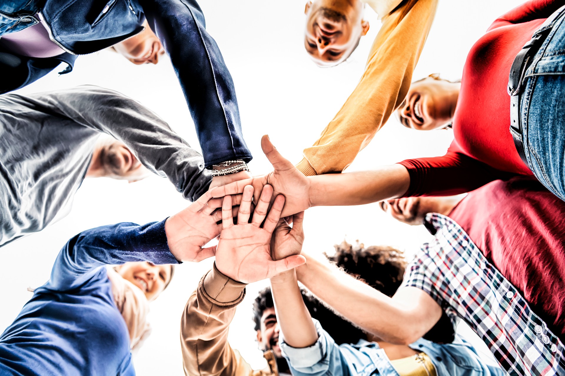 Happy multiracial young people team stacking hands together bottom view - Close up view of community of friends putting their hands together - Unity, supporting and teamwork concept